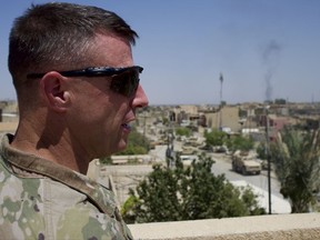 Colonel Pat Work of the U.S. Army's 82nd airborne division looks at the skyline, as he meets with Iraqi commanders near the front lines, on the rooftop of a house in Mosul, Friday,  June 30, 2017. He warned that as Iraqi forces close in on the Islamic State group's last remaining positions in Mosul the troops are at increased risk of friendly fire attacks.  (AP Photo/Balint Szlanko)
