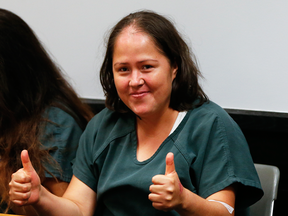 Isabel Martinez, who  is charged with killing four of her children and her husband, gestures towards news cameras during her first court appearance Friday, July 7, 2017, in Lawrenceville, Ga.