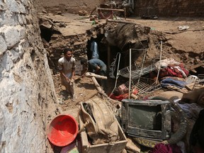 Pakistani villagers salvage belongings from their collapsed house after heavy rains, in Peshawar, Pakistan, Thursday, July 13, 2017. Pakistan's National Disaster Management Authority issued a flash flood warning after monsoon rains lashed various parts of the country, killing at least seven people. (AP Photo/Muhammad Sajjad)