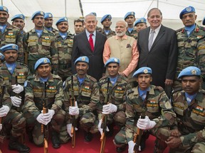 Indian Prime Minister Narendra Modi, center right, and Israeli Prime Minister Benjamin Netanyahu, center left, pose for a picture with members of the Indian contingent of United Nations Interim Force in Lebanon, during a visit to the World War I Indian Army cemetery, in the Israeli coastal city of Haifa, Israel, Thursday, July 6, 2017. (Jack Guez, Pool, via AP)