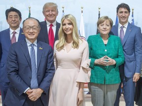 Japanese Prime Minister Shinzo Abe, left to right, World Bank President Jim Yong Kim, United States President Donald Trump, his daughter Ivanka Trump, German Chancelor Angela Merkel and Prime Minister Justin Trudeau pose for a photo after the Women and Development event at the G20 summit Saturday, July 8, 2017 in Hamburg, Germany.