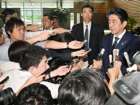 Japanese Prime Minister Shinzo Abe, right, speaks to reporters at his official residence, a day after his Liberal Democratic Party's big loss at Tokyo assembly election in Tokyo, Monday, July 3, 2017. The new party of the Japanese capital's populist governor Yuriko Koike appeared headed for a thumping victory Sunday over Prime Minister Shinzo Abe's scandal-laden ruling party in a Tokyo assembly election that could alter national politics, with Abe's historic defeat likely making it difficult for him to achieve his agenda.(Yoshinobu Shimizu/Kyodo News via AP)