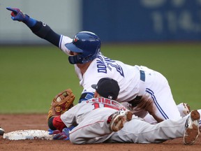 Josh Donaldson of the Toronto Blue Jays beats the tag of Dustin Pedroia of the Boston Red Sox on a play at second base during MLB action Friday night at Rogers Centre. The Red Sox rallied from a 3-0 deficit to pull out a 7-4 victory in 11 innings.