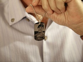 FILE -- In this June 17, 2017 file photo, Brian McEnroe, the father of fallen U.S. Green Beret Kevin McEnroe, displays a memorial dog tag depicting his fallen son, in Amman, Jordan. First Sgt. Marik al-Tuwayha, the Jordanian soldier charged with killing three U.S. Army Green Berets including McEnroe, in November 2016, told a military court Tuesday, July 4, 2017, that he opened fire because he thought fellow Jordanian troops had come under attack. Al-Tuwayha said he felt no resentment toward Americans and that he had joked and chatted with the U.S. trainers before the incident. (AP Photo/Sam McNeil)