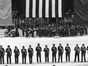 FILE - In this Feb. 24, 1980, file photo, members of the USA ice hockey team stand on ice in the arena in Lake Placid, N.Y., with hands across their chests during the playing of the national anthem at awards ceremonies. The U.S. team won the gold medal in Olympic ice hockey, the first time since 1960. Their achievement came when they defeated Finland, 4-2, earlier in the day. The anthem has been a standard part of U.S. sports games since World War II. Experts say Game 1 of the 1918 World Series between the Boston Red Sox and the Chicago Cubs helped pave the way. The song became the official national anthem in 1931. (AP Photo, File)