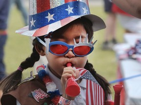 Eight-year-old Hana Cho from Girl Scout Troop 5665 tests out a horn prior to participating the Fourth of July parade in Santa Monica, Calif. on Tuesday, July 4, 2017. Decked out in red, white and blue, Californians waved flags and sang patriotic songs at Independence Day parades across the state. (AP Photo/Richard Vogel)