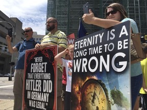 In this Wednesday, July 19, 2017, abortion opponents with a group called Operation Save America gather during a rally in downtown Louisville, Ky.  A federal judge issued an order Friday, July 21, 2017, to keep protesters away from a "buffer zone" outside Kentucky's only abortion clinic, which is targeted by a national anti-abortion group.  U.S. District Judge David J. Hale issued a temporary restraining order sought by federal prosecutors in a pre-emptive move ahead of vigils by Operation Save America. The order is aimed at preventing abortion foes from impeding access to EMW Women's Surgical Center in Louisville. . (AP Photo/Dylan Lovan)