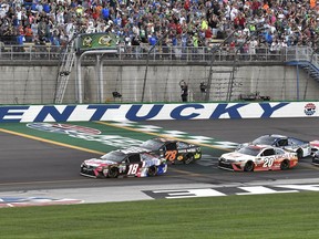 Kyle Busch (18) leads the pack across the line to start the NASCAR Cup auto race at Kentucky Speedway, Saturday, July 8, 2017, in Sparta, Ky. (AP Photo/Timothy D. Easley)