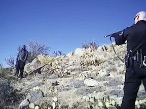 FILE - This file image made from a March 16, 2014 video shows James Boyd, 38, left, during a standoff with officers in the Sandia foothills in Albuquerque, N.M., before police fatally shot him. Federal prosecutors say there's not enough evidence to pursue criminal civil rights charges against the Albuquerque police officers involved in the 2014 fatal shooting of Boyd. The U.S. Justice Department announced Tuesday, July 18, 2017 it was closing its investigation into the death of Boyd and had met with his family and their representative to inform them. The murder case against the officers ended in a mistrial, and they were later cleared by state prosecutors.(Albuquerque Police Department via AP, File )