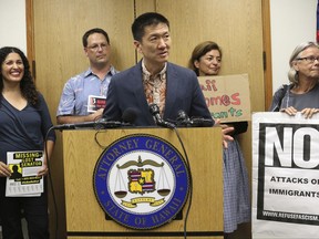 FILE - In this June 30, 2017, file photo, Hawaii Attorney General Douglas Chin speaks at a news conference about President Donald Donald Trump's travel ban in Honolulu. Hawaii's push to expand the list of relatives exempt from President Donald Trump's ban on travelers from six mostly Muslim countries is bogged down in court, where it has bounced from a federal judge to a federal appeals court and back to the same federal judge. (AP Photo/Caleb Jones, File)