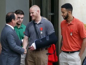 FILE - In this Aug. 24, 2015 file photo, French President Francois Hollande bids farewell to U.S. Airman Spencer Stone as U.S. National Guardsman Alek Skarlatos of Roseburg, Ore., second from left, and Anthony Sadler, a senior at Sacramento State University in California, right, look on after Hollande awarded them with the French Legion of Honor at the Elysee Palace in Paris. The three Sacramento-area men who thwarted a terror attack on a French train in 2015 will play themselves in a Clint Eastwood-directed film about their heroic feat. Sadler, Skarlatos, and Stone will star in "15:17 to Paris," which began production this week. (AP Photo/Michel Euler, File)