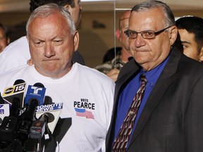 FILE - In this Nov. 8, 2011 file photo, Arizona State Sen. Russell Pearce, R-Mesa, left, prepares to address the media in Mesa, Ariz., after losing his recall election bid, as Maricopa County Sheriff Joe Arpiao, right, stands by his side. Pearce,  Pearce, a former Arizona lawmaker known as the driving force behind most of the state's toughest immigration laws is moving to challenge the university system for temporarily allowing young immigrants protected from deportation to keep paying lower-cost in-state tuition. Pearce sent a letter Tuesday, July 11, 2017, to state Attorney General Mark Brnovich giving him 60 days to sue the Arizona Board of Regents over its decision on the tuition issue or threatened to take legal action himself. (AP Photo/Matt York, File)