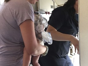 This June 22, 2017 photo provided by Maria de Los Angeles-Baida shows Emily France with her 4-month-old son Owen in Denver. France who says the infant overheated on a delayed United Airlines flight at Denver's airport, has hired an attorney and hopes the Federal Aviation Administration takes note. (Maria de Los Angeles-Baida via AP)
