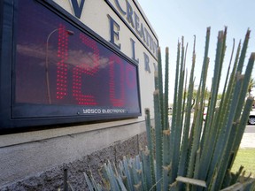 FILE - In this June 20, 2016 file photo, a sign in direct sunlight indicates 120 degrees in Phoenix. A proposed new law that would require carmakers to build alarms for backseats is being pushed by child advocates who say it will prevent kids from dying in hot cars and also streamline the criminal process against caregivers who cause the deaths, cases that can be inconsistent but often heavier-handed against mothers. The latest deaths came in Arizona on triple-digit degree days over the last weekend of July 2017. (AP Photo/Matt York, File)