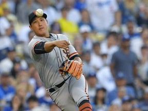 San Francisco Giants third baseman Jae-Gyun Hwang, of South Korea, attempts to throw out Los Angeles Dodgers' Enrique Hernandez at first during the seventh inning of a baseball game Sunday, July 30, 2017, in Los Angeles. Hernandez was safe at first on the play. (AP Photo/Mark J. Terrill)