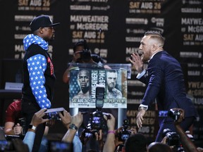 Conor McGregor, right, taunts Floyd Mayweather Jr. while pausing for photos during a news conference at Staples Center on Tuesday, July 11, 2017, in Los Angeles. The two will fight in a boxing match in Las Vegas on Aug. 26. (AP Photo/Jae C. Hong)