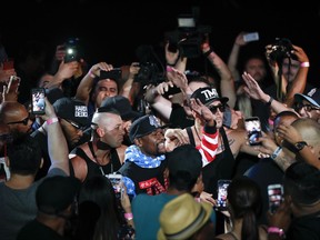 Fans cheer as Floyd Mayweather Jr., center, arrives for a news conference at Staples Center on Tuesday, July 11, 2017, in Los Angeles. Mayweather Jr. is scheduled to fight Conor McGregor in a boxing match in Las Vegas on Aug. 26. (AP Photo/Jae C. Hong)