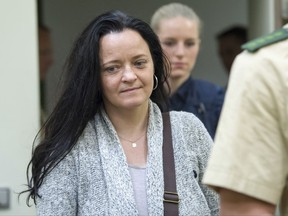 The defendant Beate Zschaepe arrives at the court room of the Higher Regional Court in Munich, Germany, 25 July 2017. Prosecutors have started their closing arguments in Germany's biggest neo-Nazi murder trial after more than four years of evidence. The main defendant Zschaepe, has been on trial since May 2013 for alleged involvement in 10 murders as a member of a group calling itself the National Socialist Underground. (Peter Kneffel/dpa via AP)