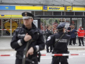 Police officers secure the area after a knife attack at a supermarket in Hamburg, Germany, Friday, July 28, 2017. German police say one person died and several people suffered stab wounds.