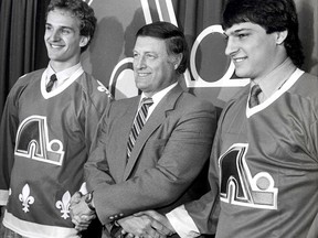 Maurice Filion, director manager of the Quebec Nordiques, welcomes Mario Brunetta, left, and Jason Lafreniere to the team, in Quebec City on June 4, 1986.