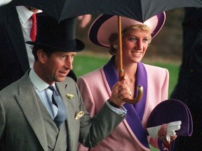 In this Wednesday, June 20, 1990 file photo, Britain's Princess Diana and Prince Charles, take shelter under an umbrella while attending the second day of the Royal Ascot horse race meet near London.