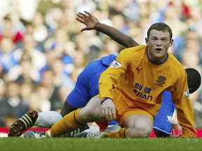 FILE - In this Saturday, April 17, 2004 file photo, Chelsea's Geremi, behind falls as Everton's Wayne Rooney appeals for a foul, during their English Premier League soccer match at Chelsea's Stamford Bridge ground in west London. Wayne Rooney has left Manchester United to rejoin Everton after 13 years at Old Trafford, it was announced on Sunday, July 9, 2017. Everton says Rooney signed a two-year contract.(AP Photo/Alastair Grant, file)