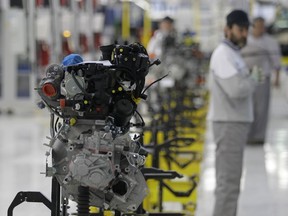 FILE This file photo from Monday, April 16, 2012 shows a factory worker looking at an engine of a Fiat 500 L car in the assembly hall in the Fiat factory, in Kragujevac, some 100 kilometers (70 miles) south of Belgrade, Serbia. Hundreds of Fiat workers marched from the Serbian factory on Tuesday, July 18, 2017, to demand higher wages. (AP Photo/Darko Vojinovic, File)
