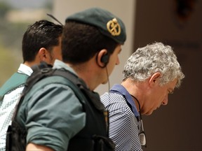 FILE - A Tuesday, July 18, 2017 file photo showing former President of the Spanish Football Federation, Angel Maria Villar, right, as he is lead by Spanish Civil Guard policeman to enter the Federation headquarters during an anti-corruption operation in Las Rozas, outside Madrid. The opening of the disciplinary procedure on Monday, July 24, 2017, clears the way for Spain's sports authority, the Higher Council of Sport, to rule whether it will temporarily suspend Villar when they meet on Tuesday at 7 p.m. local time (1700 GMT). (AP Photo/Francisco Seco, File)
