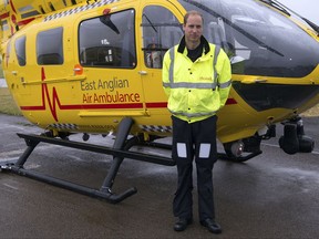 FILE - This is a Monday July 13, 2015  file photo of Britain's Prince William, as he poses in front of an East Anglian Air Ambulance (EAAA) as he begins his new role, at Cambridge Airport, Cambridge, in England. Prince William is completing his final shift in his job as an air ambulance pilot as he gets ready to take on more extensive royal duties. The heir to the British throne is working the night shift Thursday July 27, 2017 at the East Anglian Air Ambulance, where he has been flying medical crews to emergencies such as traffic accidents for about two years. (Stefan Rousseau, Pool, File via AP)
