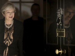 Britain's Prime Minister Theresa May walks through the door to greet Australian Prime Minister Malcolm Turnbull at 10 Downing Street in London Monday July 10, 2017.  The British and Australian prime ministers are holding bi-lateral talks.  (Stefan Rousseau/PA via AP)