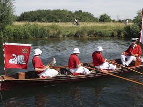 Swan Uppers row near Shepperton Lock, England, as the ancient tradition of counting swans along the River Thames begins, Monday July 17, 2017. The ritual known as Swan Upping dates back to the 12th century when the ownership of all unmarked mute swans in open water in Britain was claimed by the Crown in order to ensure a ready supply for feasts. (Steve Parsons/PA via AP)