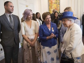 Britain's Queen Elizabeth II meets with guests at Canada House in Trafalgar Square, central London, Wednesday July 19, 2017, marking the 150th anniversary of Canada's Confederation.  The queen will meet various dignitaries and guests during her visit to celebrate the establishment of modern Canada 150-years ago.  (Stefan Rousseau/PA via AP)