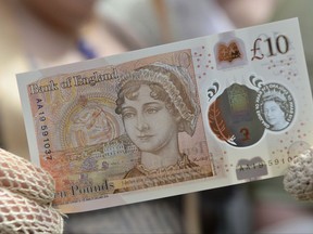 People in period costume display the new £10 note featuring Jane Austen, which marks the 200th anniversary of Austen's death, during the unveiling at Winchester Cathedral, England, Tuesday, July 18, 2017. At the unveiling Tuesday of the new 'tenner' at Winchester Cathedral in southern England, Bank of England Governor Mark Carney said the new note celebrates the "universal appeal" of Austen's work. (Chris J Ratcliffe/PA via AP)