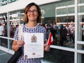 Byrdie Funk shows off her Certificate of Canadian Citizenship outside of a citizenship ceremony at Canada Place in Vancouver B.C.