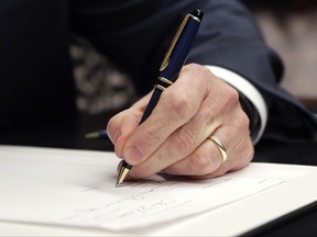 Mass. Gov. Charlie Baker signs into law the Pregnant Workers Fairness Act during a ceremony at the Statehouse, Thursday, July 27, 2017, in Boston. (AP Photo/Charles Krupa)