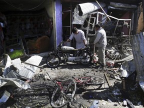 Men look at the remains of their properties at the site of a suicide attack in Kabul, Afghanistan, Monday, July 24, 2017. A suicide car bomb killed dozens of people as well as the bomber early Monday morning in a western neighborhood of Afghanistan's capital where several prominent politicians reside, a government official said. (AP Photos/Massoud Hossaini)