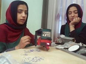 In this Thursday, July 6, 2017 photo, Sumaya Farooqi, 14, left, practices robotics with her colleagues, at the Better Idea Organization center, in Herat, Afghanistan. Six female students from war-torn Afghanistan who had hoped to participate in an international robotics competition July 16-18 in Washington D.C will have to watch via video link after the U.S. denied them visas -- not once, but twice. Of 162 teams participating, the Afghan girls are the only nation's team to be denied visas. (AP Photos/Ahmad Seir)