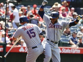 Seattle Mariners' Robinson Cano, right, celebrates with Kyle Seager after his three-run home run during the eighth inning of a baseball game against the Los Angeles Angels in Anaheim, Calif., Sunday, July 2, 2017. (AP Photo/Chris Carlson)