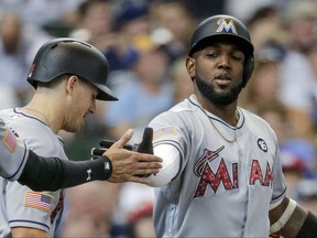 Miami Marlins' Marcell Ozuna, right, gets a hand slap after hitting a three-run home run off of Milwaukee Brewers' Junior Guerra during the third inning of a baseball game Sunday, July 2, 2017, in Milwaukee. (AP Photo/Tom Lynn)