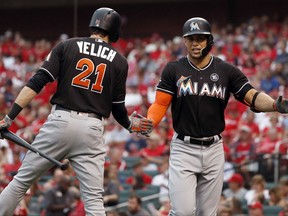 Miami Marlins' Giancarlo Stanton, right, is congratulated by teammate Christian Yelich after hitting a solo home run during the first inning of the team's baseball game against the St. Louis Cardinals on Wednesday, July 5, 2017, in St. Louis. (AP Photo/Jeff Roberson)