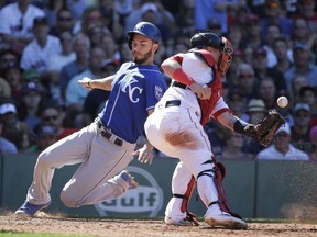 Kansas City Royals' Eric Hosmer, left, scores on a hit by Royals' Alcides Escobar as Boston Red Sox's Christian Vazquez, right, tries to get his glove on the ball in the eighth inning of a baseball game, Sunday, July 30, 2017, in Boston. (AP Photo/Steven Senne)