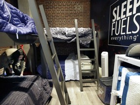 In this Wednesday, May 31, 2017, photo, Zineb Curran, left, Boston Red Sox senior director of corporate communications, arranges bedding in a nap station near the team's clubhouse at Fenway Park in Boston. Day-night doubleheaders. Cross-country travel. Rain delays and extra innings. A baseball season can play havoc with a player's sleep schedule, but the Red Sox think they have one answer with a room for napping. (AP Photo/Steven Senne)