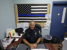In this Tuesday, July 11, 2017, photo Taunton police Lt. Paul Roderick sits behind his desk at police headquarters in Taunton, Mass. Police departments are increasingly using Facebook to inform the community about what they're doing and who they're arresting. Some add a little humor to the mix. Civil rights advocates complain that posting mugshots and written, pejorative descriptions of suspects amounts to public shaming. Roderick recently wrote and posted an account of the arrest of Amy Rebello-McCarthy. (AP Photo/Stephan Savoia)