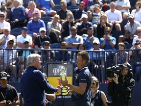 Defending champion Henrik Stenson of Sweden, right, hands over the Claret Jug to Martin Slumbers, Chief Executive of the R&A, during the second practice day at the British Open Golf Championship at Royal Birkdale in Southport, England, Monday, July 17, 2017. (AP Photo/Dave Thompson)
