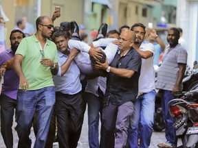 Maldivian lawmaker Faisal Naseem who was injured in clashes with police is rushed to a hospital in Male, Maldives, Monday, July 24, 2017. The Maldivian opposition says the military has locked down parliament on the orders of the country's president in a bid to prevent lawmakers from taking part in a vote to impeach the parliamentary speaker. (AP Photo/Ahmed Shurau)