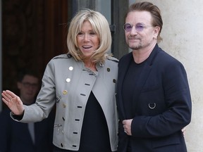 Brigitte Macron the wife of French President Emmanuel Macron, left, and founder of the non-governmental organization ONE, U2 singer Bono, pose for the media after a meeting at the Elysee Palace, in Paris, France, Monday, July 24, 2017. French President Emmanuel Macron has received pop singer and philanthropist Bono at the Elysee Palace in Paris for talks about poverty.(AP Photo/Michel Euler)