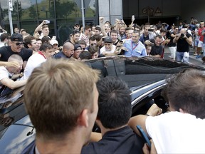 AC Milan fans surround a car in which Italy defender Leonardo Bonucci is traveling in as it arrives at AC Milan's offices, in Milan, Italy, Friday, July 14, 2017. Bonucci is close to completing a transfer from Juventus to rival AC Milan that could signal a shift in the balance of power in Serie A.  (AP Photo/Luca Bruno)