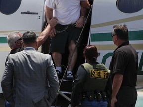 Aramazd Andressian Sr., top, a suspect in killing of his missing 5-year-old son, is escorted off a plane in shackles after landing at the Long Beach Airport, Friday, June 30, 2017, in Long Beach, Calif. Andressian Sr. has been extradited to Los Angeles to face a murder charge in the disappearance of his 5-year-old son. (AP Photo/Jae C. Hong)