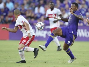Orlando City's Cyle Larin (9) moves the ball past Toronto FC's Jason Hernandez (12) during an MLS soccer match Wednesday, July 5, 2017, in Orlando, Fla. (Stephen M. Dowell/Orlando Sentinel via AP)