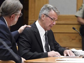 Attorney James Fleming puts his hand on David Pettersen's shoulder as Pettersen reads a statement during a sentencing hearing Tuesday, July 11, 2017, at the Watonwan County Courthouse in St. James, Minn. Pettersen who shot and killed an intruder who was fleeing from his home has been sentenced to 90 days in jail. (Pat Christman/The Free Press via AP)